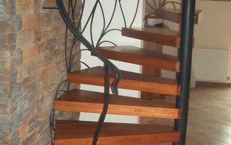 ocelova-konstrukcia-tocitych-schodov---drevene-schodnice-s-ozdobnym-kovanym-zabradlim